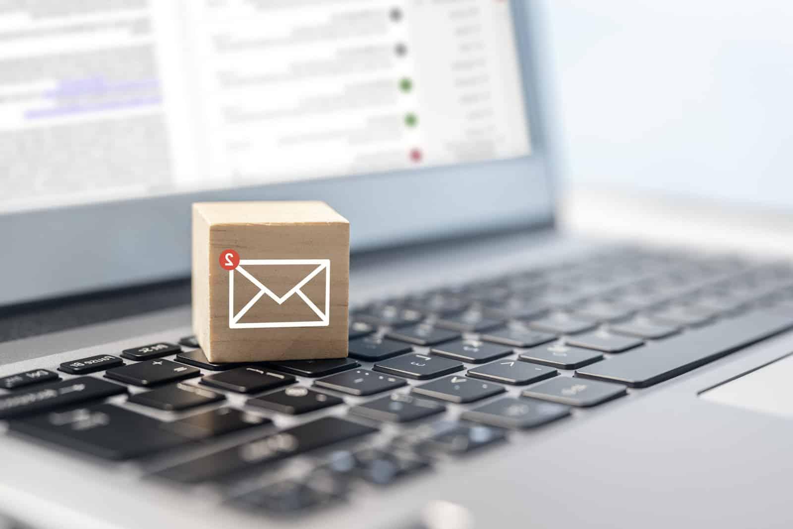 新的电子邮件符号在木块上的笔记本电脑键盘